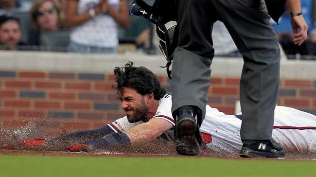 Atlanta Braves Dansby Swanson slides safely into home plate on a hit against the Kansas City Royals during the first inning of a baseball game Tuesday, July 23, 2019, in Atlanta. (AP Photo/Tami Chappell)