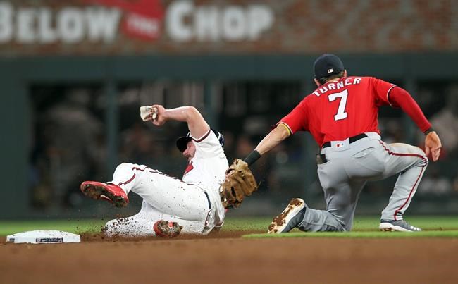 Washington Nationals shortstop Trea Turner, right, tags out Atlanta Braves Matt Joyce on a fielder's choice in the second inning of a baseball game Saturday, Sept. 7, 2019, in Atlanta. (AP Photo/Tami Chappell)