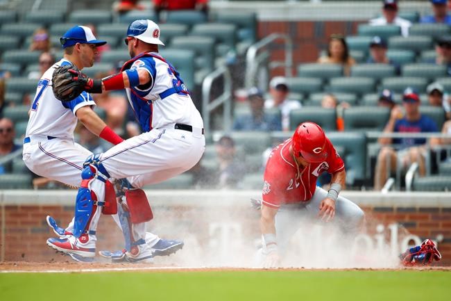 Cincinnati Reds Derek Dietrich (22) slides into home to score off a sacrifice bunt of Sonny Gray in the fourth inning of a baseball game against the Atlanta Braves, Sunday, Aug.4, 2019, in Atlanta. (AP Photo/Todd Kirkland)