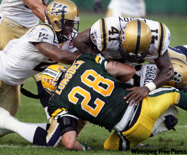 BRIAN J. GAVRILOFF / CANWEST NEWS SERVICE ARCHIVES
Jesse Lumsden was knocked out of Thursday’s game on this hit from Winnipeg Blue Bombers Siddeeq Shabazz and Fred Perry (41).