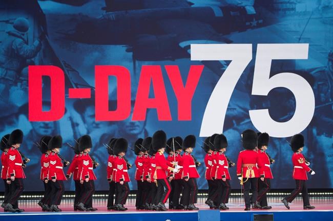 An honor guard marches on stage during a ceremony to mark the 75th Anniversary of D-Day, when the Allied soldiers, sailors and airmen conducted an invasion that helped liberate Europe from Nazi Germany, Wednesday, June 5, 2019, in Portsmouth, England. (AP Photo/Alex Brandon)