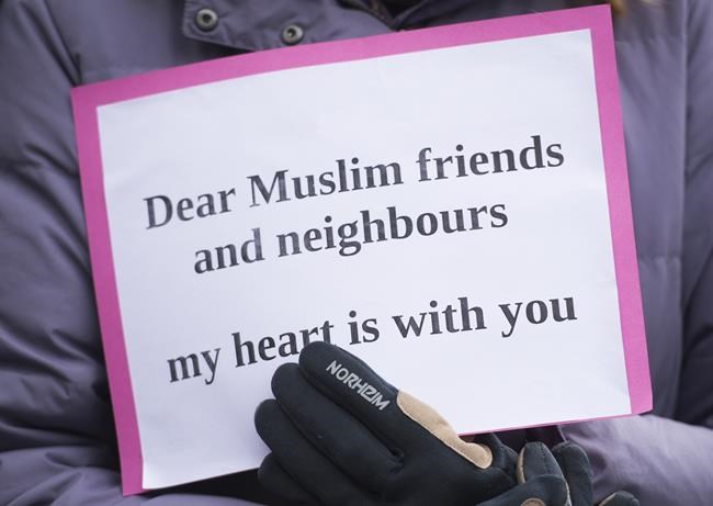 A woman holds a sign during a vigil in Montreal, Sunday, March 17, 2019, following a shooting at a mosque in Christchurch, New Zealand which left 50 people dead and many more injured.THE CANADIAN PRESS/Graham Hughes