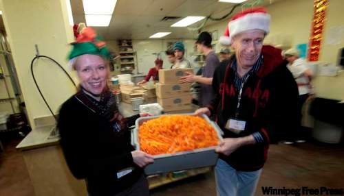 PHIL.HOSSACK@FREEPRESS.MB.CA
Katy Groenheide and Dave Delaney carry a tray of carrots at Siloam’s kitchen Tuesday night.