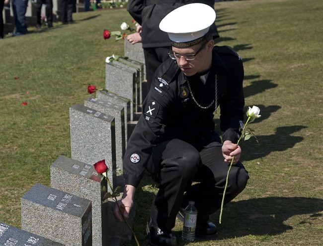 An air cadet places a flower on a grave marker at a memorial service at Fairview Lawn Cemetery to mark the 100th anniversary of the sinking of RMS Titanic in Halifax on Sunday, April 15, 2011. THE CANADIAN PRESS/Andrew Vaughan