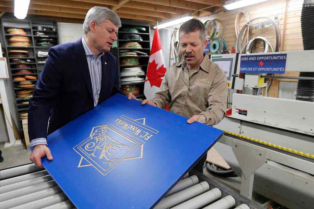 John Woods / THE CANADIAN PRESS
Prime Minister Stephen Harper and Rick Mostert, president of FC Woodworks Inc., use an Edgebender to put an edge on a piece of wood Thursday.