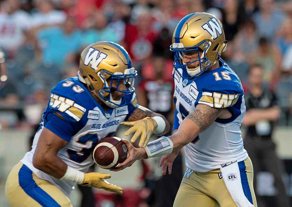 Adrian Wyld / THE CANADIAN PRESS FILES
Bombers quarterback Matt Nichols, right, hands the ball to Andrew Harris. Nichols says having someone like Harris in the backfield makes his job easier.