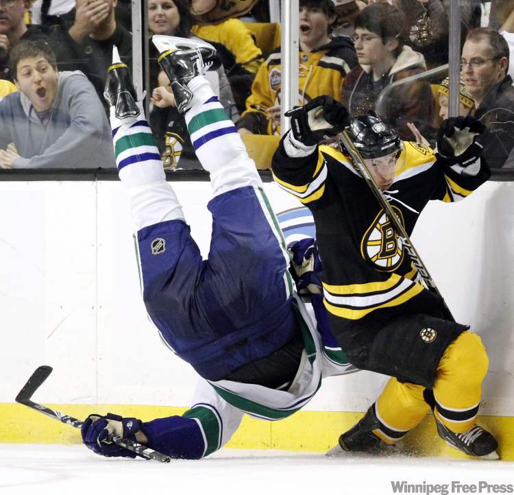 Michael Dwyer / THE CANADIAN PRESS
Boston Bruins' Brad Marchand, right, trips Vancouver Canucks' Sami Salo, left, in the second period of an NHL hockey game in Boston, Saturday, Jan. 7. Bruins general Manager Peter Chiarelli is angered after Marchand was suspended five games by the NHL for this hit.
