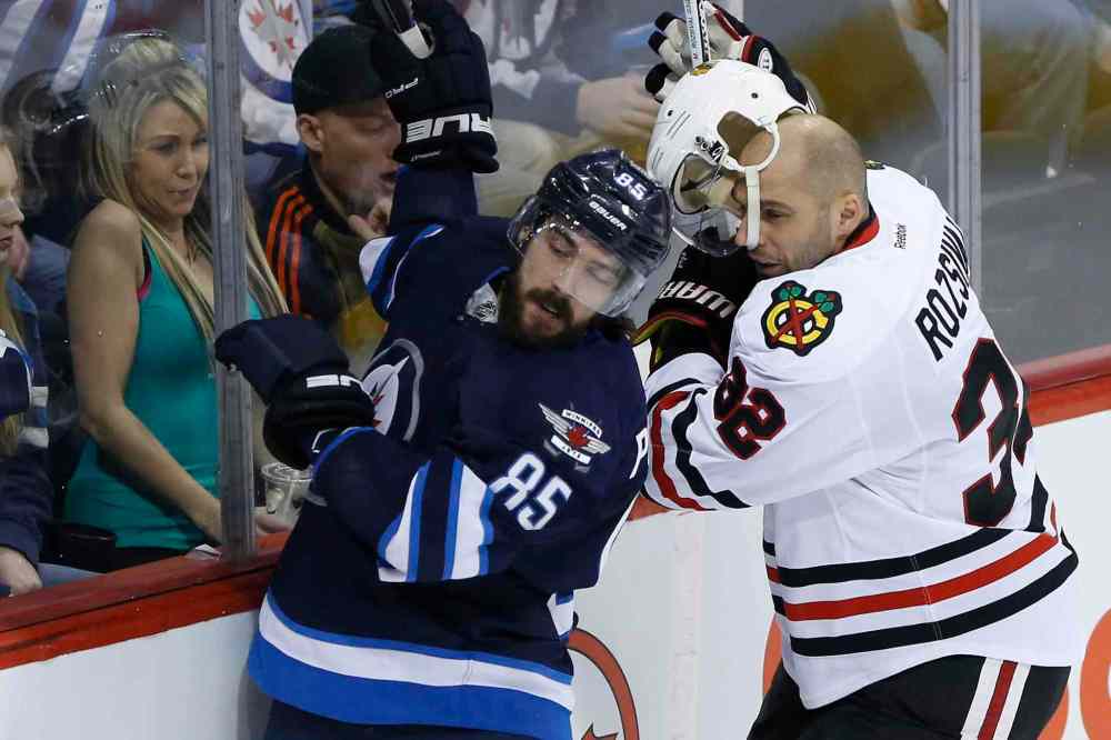 John Woods / The Canadian Press
Chicago Blackhawks' Michal Rozsival (32) loses his helmet after a hit from Winnipeg Jets' Mathieu Perreault (85) during first period NHL action in Winnipeg on Friday.