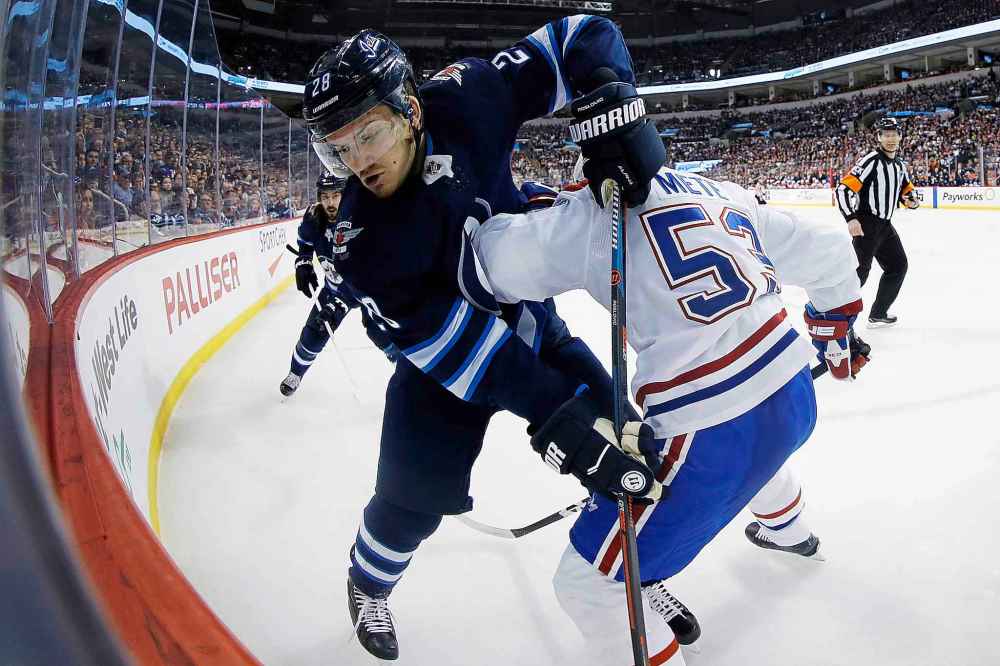 JOHN WOODS / THE CANADIAN PRESS
Winnipeg Jets' Jack Roslovic (28) and Montreal Canadiens' Victor Mete (53) fight for possession of the puck during second period NHL action in Winnipeg on Saturday, March 28, 2019.