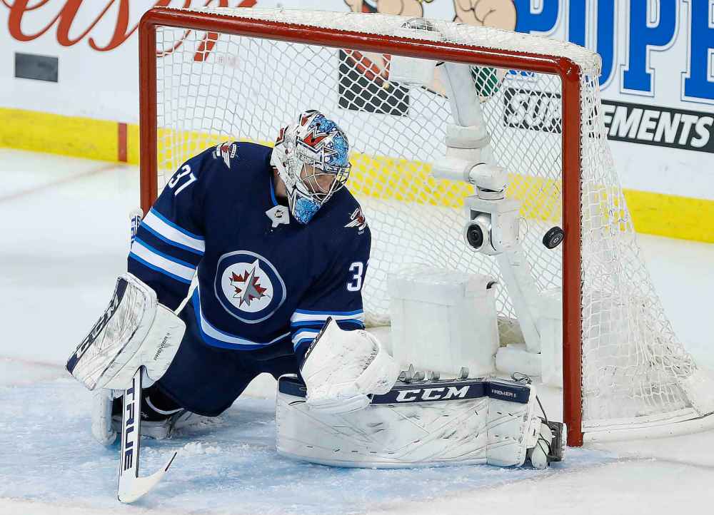 JOHN WOODS / THE CANADIAN PRESS
Winnipeg Jets goaltender Connor Hellebuyck (37) watches as a Montreal Canadiens' shot goes off the post during first period NHL action in Winnipeg on Saturday, March 28, 2019.