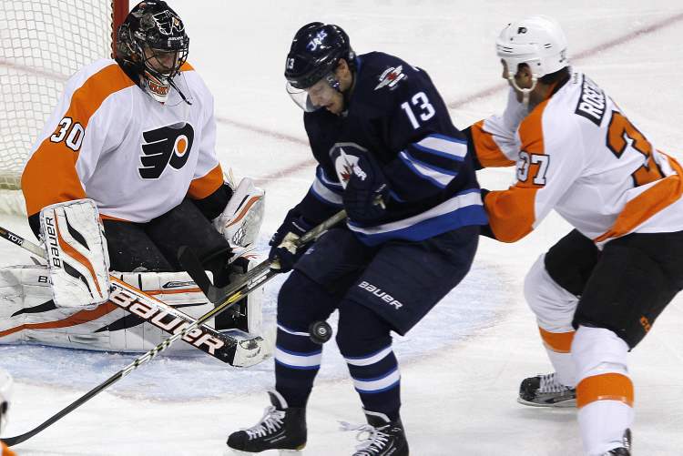 John Woods / The Canadian Press
Winnipeg Jets' Kyle Wellwood, centre, fights for the puck with Philadelphia Flyers' Jay Rosehill as goaltender Ilya Bryzgalov looks for the rebound during first period NHL action in Winnipeg on Saturday. The Jets rebounded and led the Flyers 4-1 in the second period.
