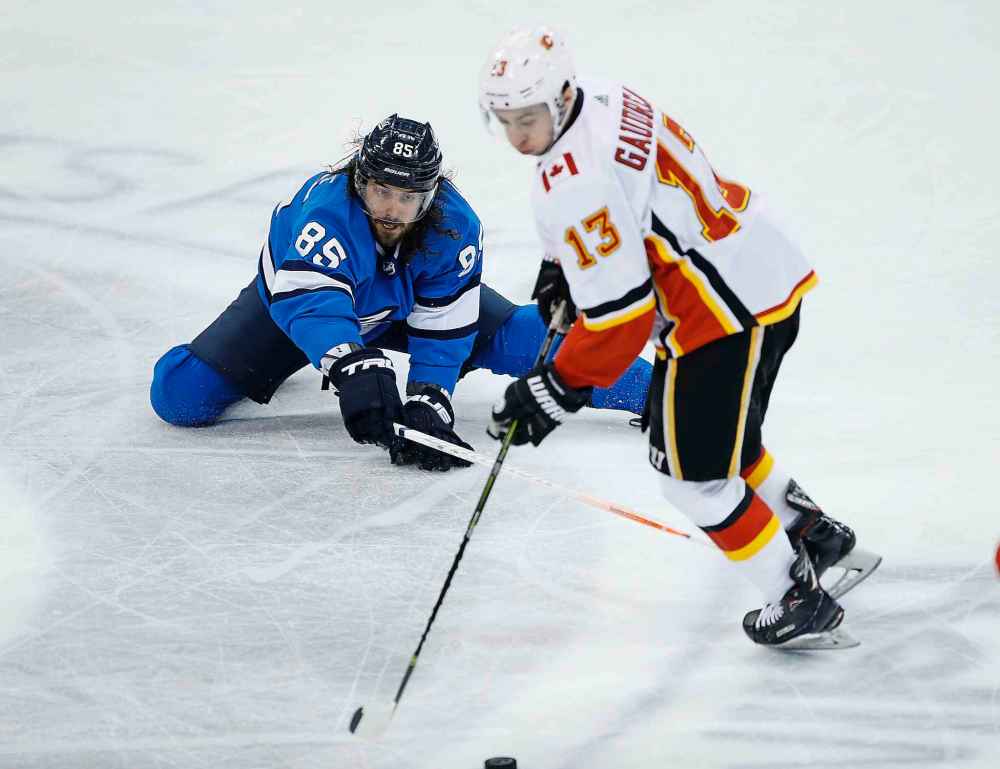 JOHN WOODS / THE CANADIAN PRESS
Winnipeg Jets' Mathieu Perreault (85) attempts to steal the puck from Calgary Flames' Johnny Gaudreau (13) during third period NHL action in Winnipeg on Saturday.