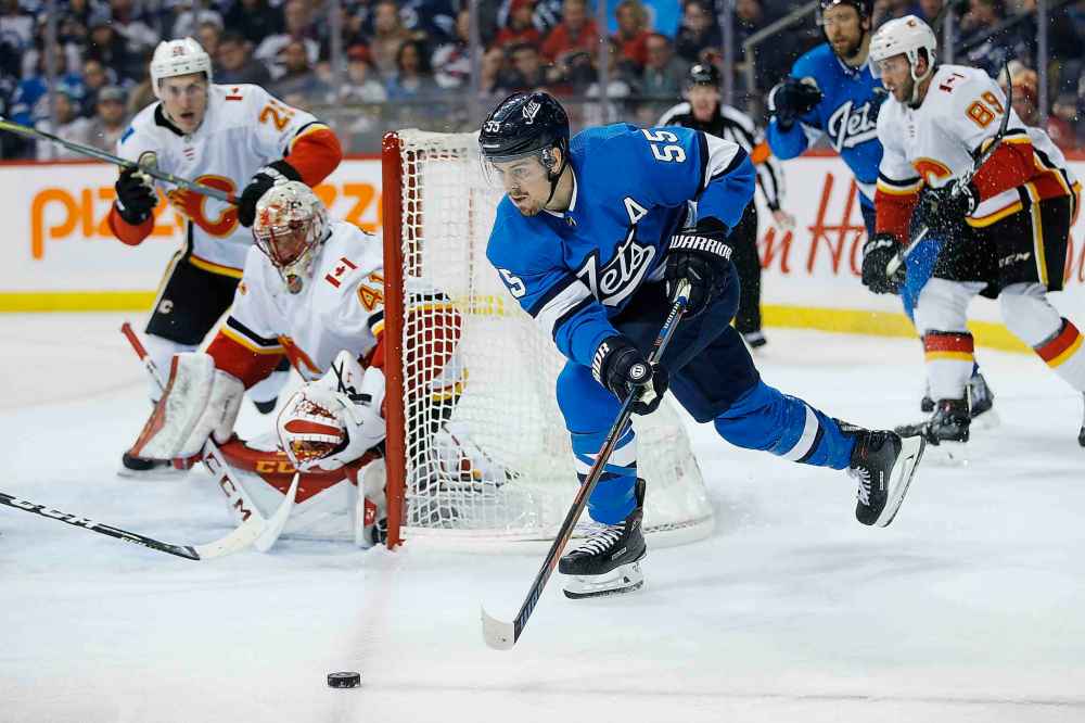 JOHN WOODS / THE CANADIAN PRESS
Winnipeg Jets' Mark Scheifele (55) makes the pass as Calgary Flames goaltender Mike Smith (41) looks on during second period NHL action.
