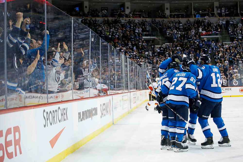 JOHN WOODS / THE CANADIAN PRESS
Winnipeg Jets' Mathieu Perreault and his teammates celebrate Perreault's go ahead goal on Calgary Flames goaltender Mike Smith (41) during second period NHL action.