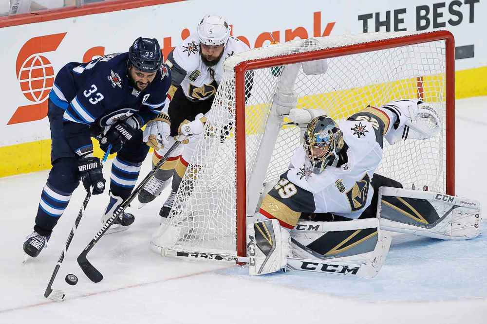 JOHN WOODS / THE CANADIAN PRESS
Winnipeg Jets' Dustin Byfuglien (33) attempts the wraparound on Vegas Golden Knights� Deryk Engelland (5) and goaltender Marc-Andre Fleury (29) during third period of game one action in the NHL Western Conference Final in Winnipeg on Saturday, May 12, 2018.