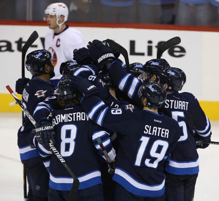Trevor Hagan / The Canadian Press
The Winnipeg Jets' mob Evander Kane (9) after he scored the game-winning overtime goal against the New York Islanders on Sunday.