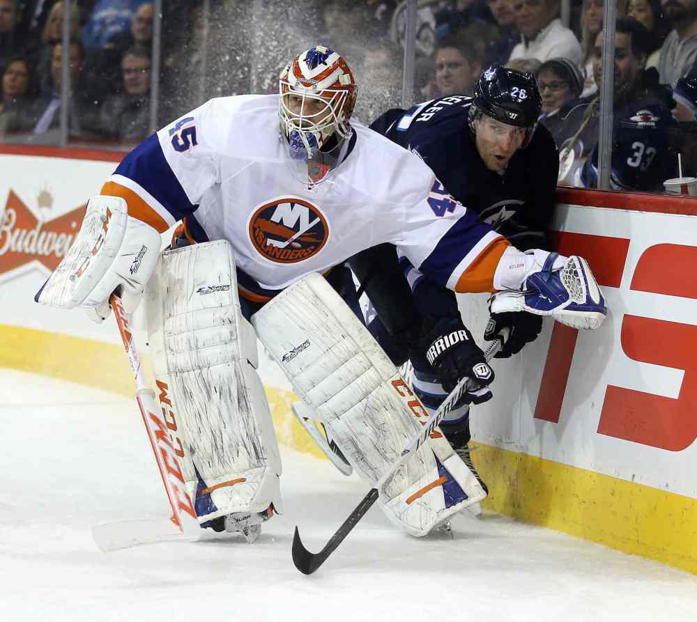 Trevor Hagan / The Canadian Press
Islanders goalie Anders Nilsson squeezes out Winnipeg forward Blake Wheeler behind the net during second-period action Tuesday night.