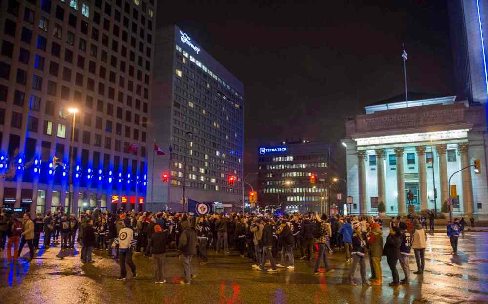 David Lipnowski/ The Canadian Press
Winnipeg Jets fans gather at the intersection of Portage Avenue and Main Street in Winnipeg on Thursday to celebrate the Winnipeg Jets clinching a NHL playoff spot.