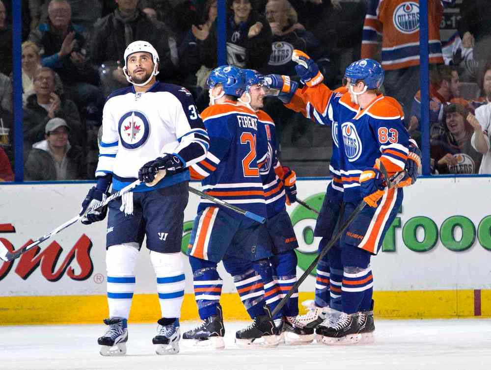 Jason Franson / The Canadian Press
Winnipeg Jets' Dustin Byfuglien (33) looks on as Edmonton Oilers' Andrew Ference (21), Jordan Eberle (14) and Ales Hemsky (83) celebrate a goal during first period NHL hockey action in Edmonton, Alta., on Monday.