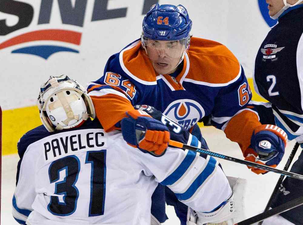 Jason Franson / The Canadian Press
Winnipeg Jets' goalie Ondrej Pavelec (31) is elbowed by Edmonton Oilers' Nail Yakupov (64) during second period NHL hockey action in Edmonton, Alta., on Monday.