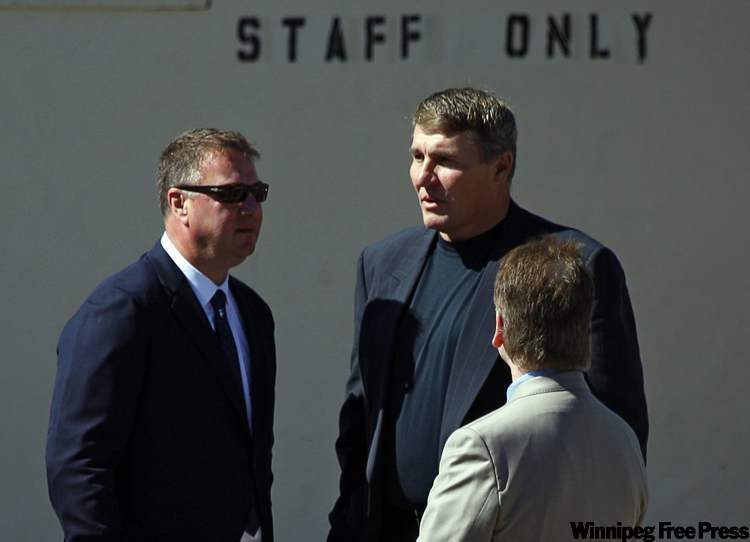 Jeff McIntosh / THE CANADIAN PRESS
Former NFL quarterback Mark Rypien, centre, talks with Vancouver Canucks general manager Mike Gillis, while attending the funeral service for his cousin Rick Rypien, 27, in Blairmore, Alta., Saturday. Rypien was found dead in his off-season Coleman, Alta., home on Aug. 15. He had just signed with the Winnipeg Jets last month after six seasons with the Vancouver Canucks.