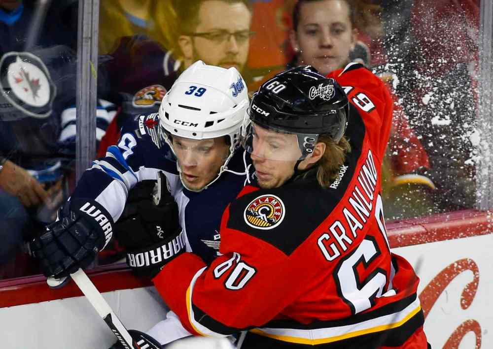 CP
Winnipeg Jets' Tobias Enstrom, left, of Sweden, is checked by Calgary Flames' Markus Granlund, from Finland, during first period NHL hockey action in Calgary, Tuesday, Dec. 22, 2015.THE CANADIAN PRESS/Jeff McIntosh