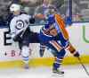 THE CANADIAN PRESS/Jason Franson
Winnipeg Jets' Adam Lowry (17) is checked by Edmonton Oilers' Justin Schultz (19) during second period NHL pre-season action in Edmonton, Alta., on Wednesday September 23, 2015.