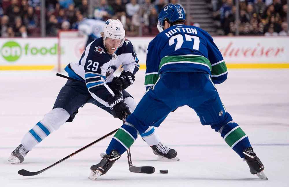 JONATHAN HAYWARD / THE CANADIAN PRESS
Winnipeg Jets right wing Patrik Laine (29) tries to get the puck past Vancouver Canucks defenceman Ben Hutton (27) during first period NHL action at Rogers Arena in Vancouver, Saturday, Dec. 22, 2018.