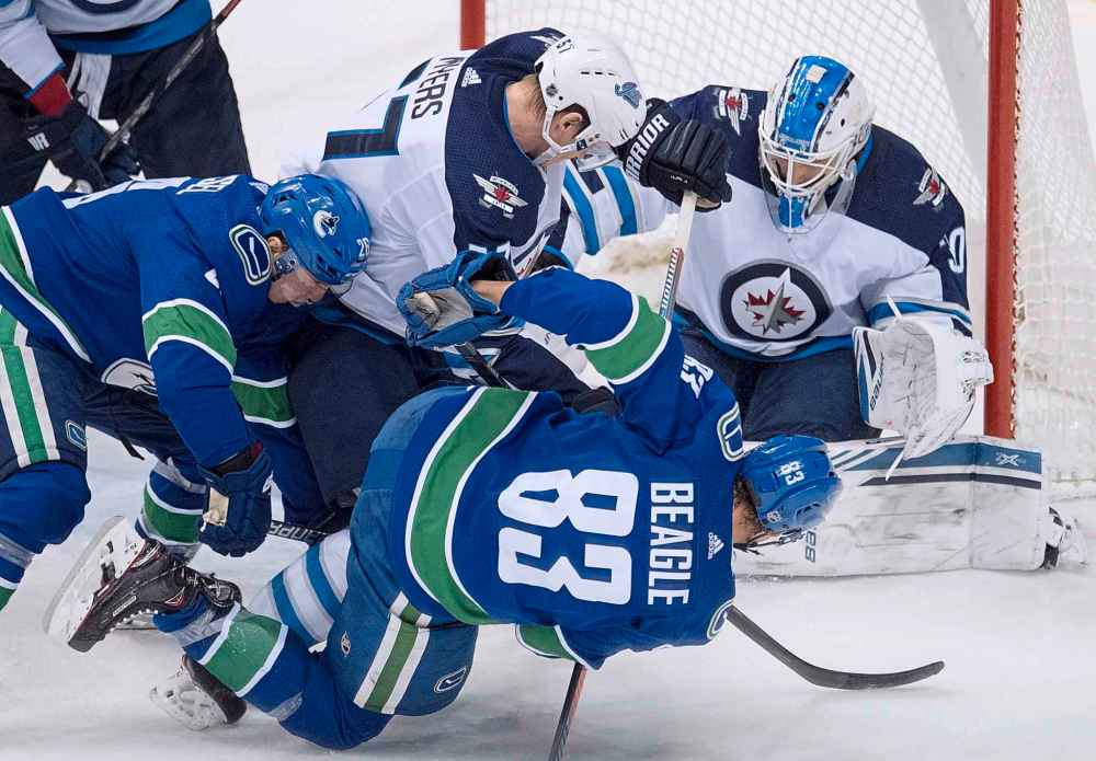 JONATHAN HAYWARD / THE CANADIAN PRESS
Winnipeg Jets defenceman Tyler Myers (57) stops Vancouver Canucks center Jay Beagle (83) from getting a shot on Winnipeg Jets goaltender Laurent Brossoit (30) during second period NHL action at Rogers Arena in Vancouver, Saturday, Dec. 22, 2018.