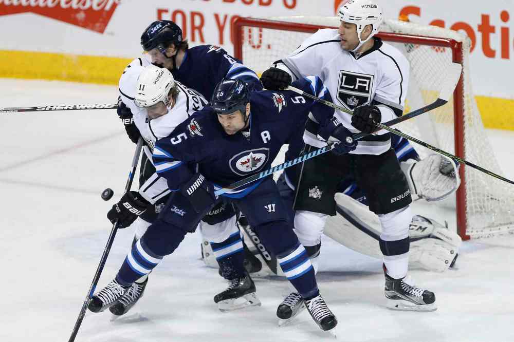 THE CANADIAN PRESS/John Woods
Winnipeg Jets' Mark Stuart (5) attempts to overpower Los Angeles Kings' Anze Kopitar (11) as he tries for the deflection and Jets' Jacob Trouba (8) and Kings' Milan Lucic (17) get in on the action during first period NHL action in Winnipeg on Thursday, March 24, 2016.