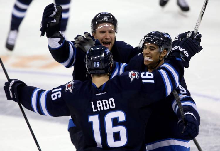 TREVOR HAGAN / THE CANADIAN PRESS
The Jets' Blake Wheeler (top) and Evander Kane (right) celebrate with Andrew Ladd after Ladd's shootout-winning goal Tuesday evening.