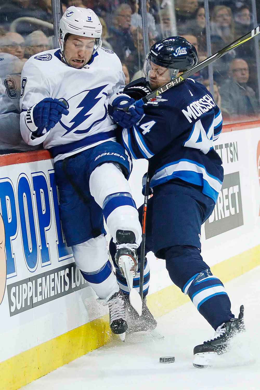 JOHN WOODS / THE CANADIAN PRESS
Winnipeg Jets' Josh Morrissey (44) drives Tampa Bay Lightning's Tyler Johnson (9) into the boards during first period NHL action in Winnipeg on Sunday, Dec. 16, 2018.