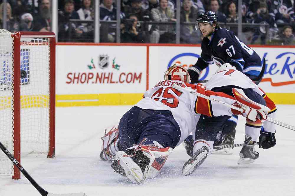 John Woods / The Canadian Press
Winnipeg Jets' Michael Frolik scores on Florida Panthers goaltender Jacob Markstrom as part of a 5-2 victory Friday. The team is on its way to Vancouver to play the Canucks Sunday.