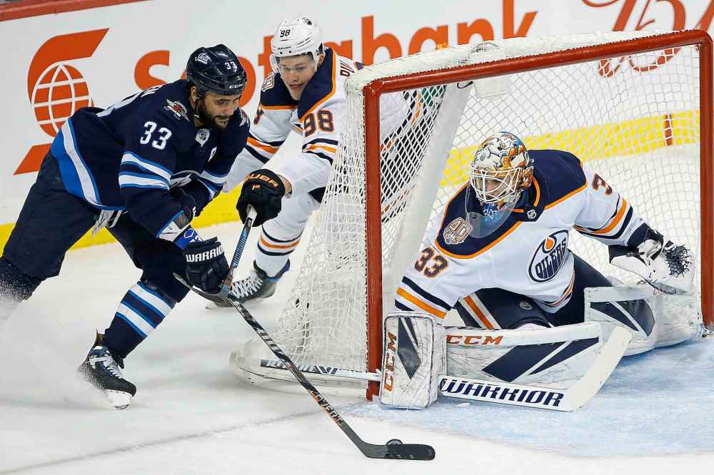 THE CANADIAN PRESS/John Woods
Winnipeg Jets' Dustin Byfuglien attempts a wrap-around shot on Edmonton Oilers goaltender Cam Talbot as Jesse Puljujarv defends during the first period in Winnipeg on Thursday.