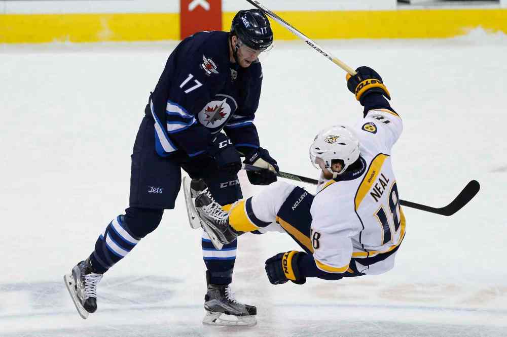THE CANADIAN PRESS/John Woods
Winnipeg Jets' Adam Lowry (17) levels Nashville Predators' James Neal (18) during first period NHL action in Winnipeg on Thursday, January 14, 2016.