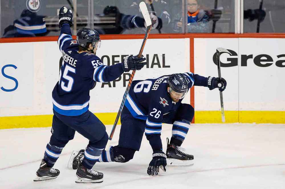 Blake Wheeler (right) and Mark Scheifele celebrate Wheeler's go-ahead goal at 14:09 of the third period. (John Woods / The Canadian Press)