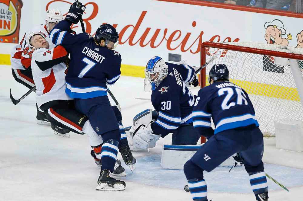 JOHN WOODS / THE CANADIAN PRESS
Winnipeg Jets goaltender Laurent Brossoit (30) saves the shots as Jets' Ben Chiarot (7) defends against Ottawa Senators' Brady Tkachuk (7) during first period NHL action.