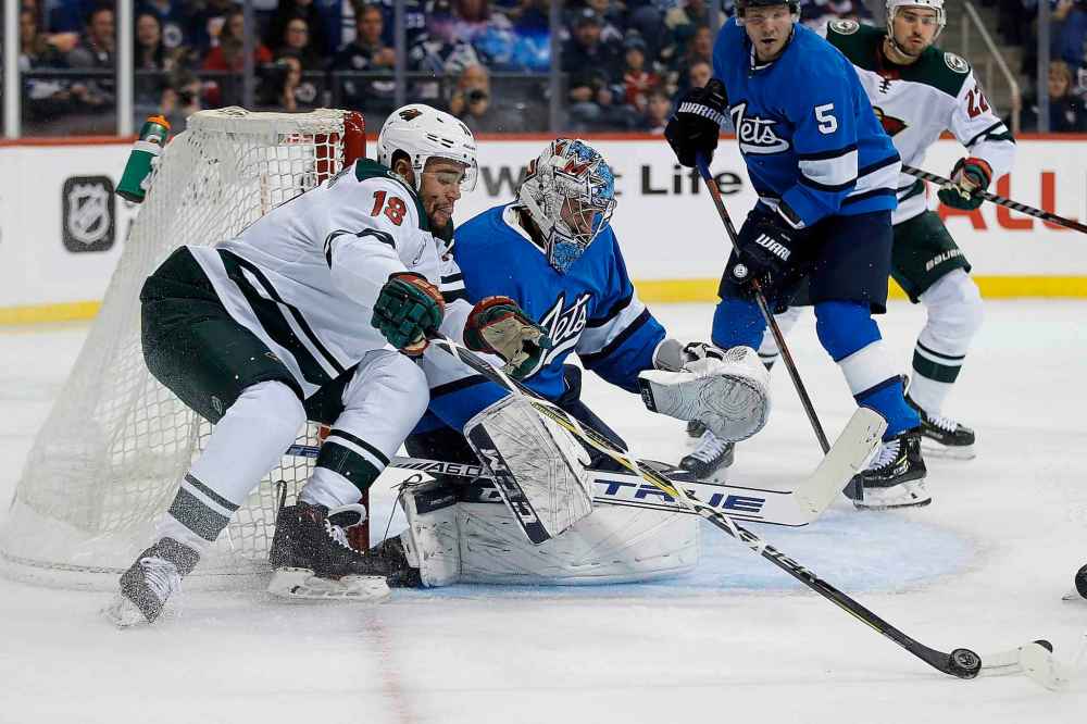 JOHN WOODS / THE CANADIAN PRESS
Minnesota Wild's Jordan Greenway (18) tries to recover the rebound off his shot on Winnipeg Jets goaltender Connor Hellebuyck (37) during first period NHL action in Winnipeg on Saturday, December 29, 2018.
