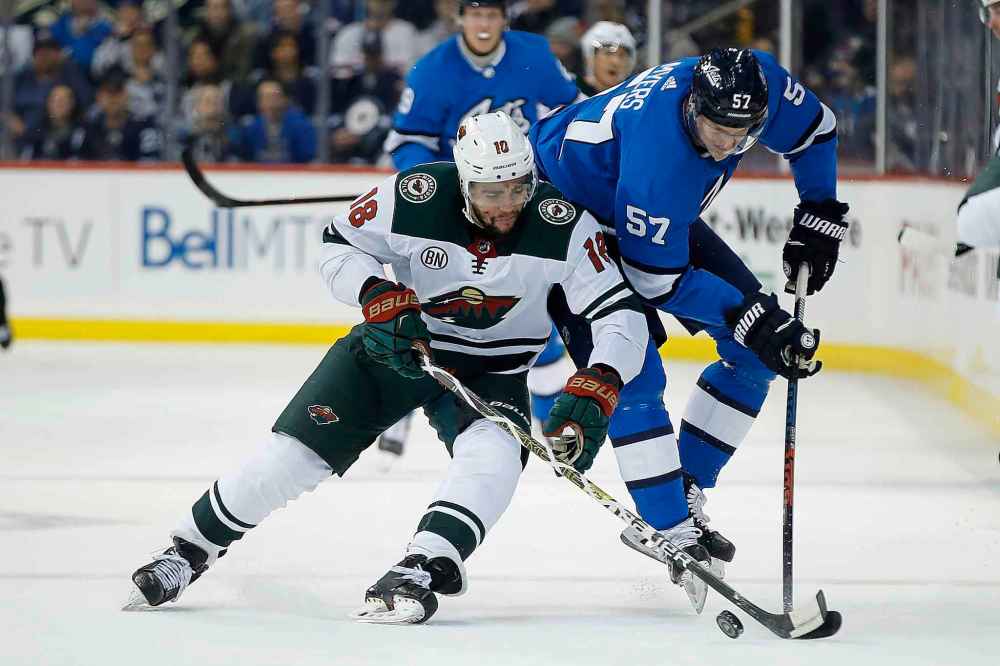 CP
JOHN WOODS / THE CANADIAN PRESS
Minnesota Wild's Jordan Greenway (18) steals the puck from Winnipeg Jets' Tyler Myers (57) during first period NHL action in Winnipeg on Saturday, December 29, 2018.