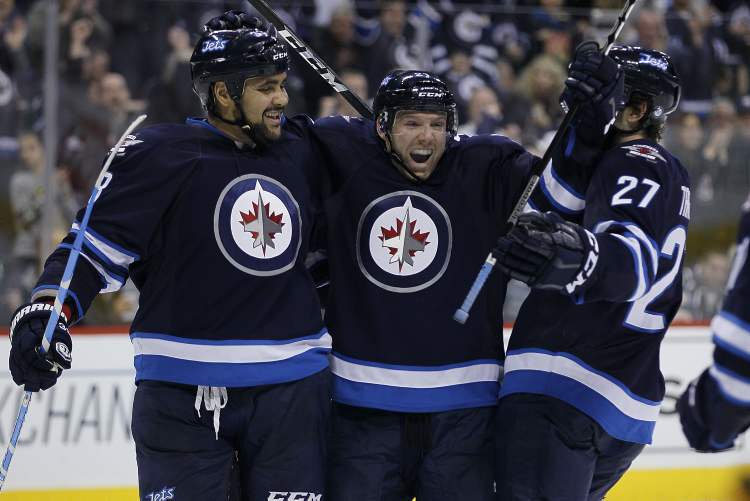 JOHN WOODS / WINNIPEG FREE PRESS
Jet Aaron Gagnon (centre), celebrates his second-period goal -- his first NHL marker -- with Dustin Byfuglien (left) and Eric Tangradi.