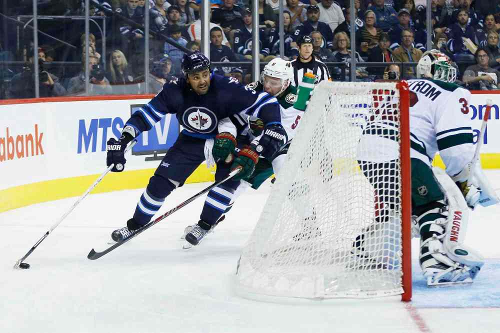JOHN WOODS / WINNIPEG FREE PRESS
The Winnipeg Jets' Dustin Byfuglien drives behind the net against the Minnesota Wild's Christian Folin in the second period Monday at the MTS Centre.