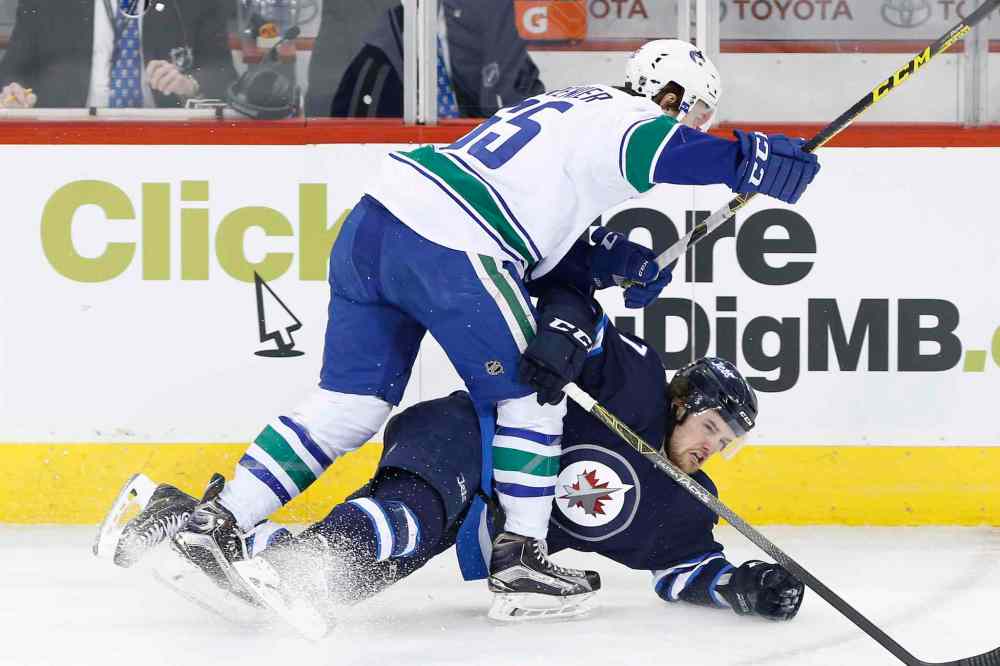 JOHN WOODS / WINNIPEG FREE PRESS
Vancouver Canucks' Alexandre Grenier (65) checks Winnipeg Jets' Chase De Leo (77) during the first period.