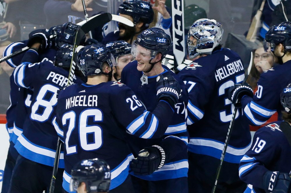 Blake Wheeler and the Jets celebrate Tyler Myers' game-winning goal Tuesday night. The Jets beat the Caps 4-3 in overtime. (John Woods / The Canadian Press)