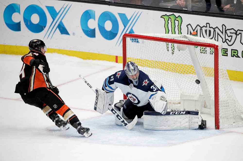 (AP Photo/Jae C. Hong)
Anaheim Ducks' Adam Henrique, left, scores against Winnipeg Jets goaltender Connor Hellebuyck during the shootout in an NHL hockey game Thursday, Jan. 25, 2018, in Anaheim, Calif. The Ducks won 4-3.