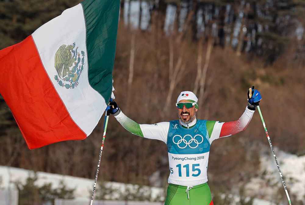 CP
German� Madrazo, of Mexico, holds up his flag after finishing last in the men's 15km freestyle cross-country skiing competition at the 2018 Winter Olympics in Pyeongchang, South Korea, Friday, Feb. 16, 2018. (AP Photo/Kirsty Wigglesworth)
