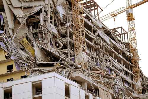 Debris hangs on the side of the building after a large portion of a hotel under construction suddenly collapsed in New Orleans on Saturday, Oct. 12, 2019. Several construction workers had to run to safety as the Hard Rock Hotel, which has been under construction for the last several months, came crashing down. It was not immediately clear what caused the collapse or if anyone was injured.  (Scott Threlkeld/The Advocate via AP)