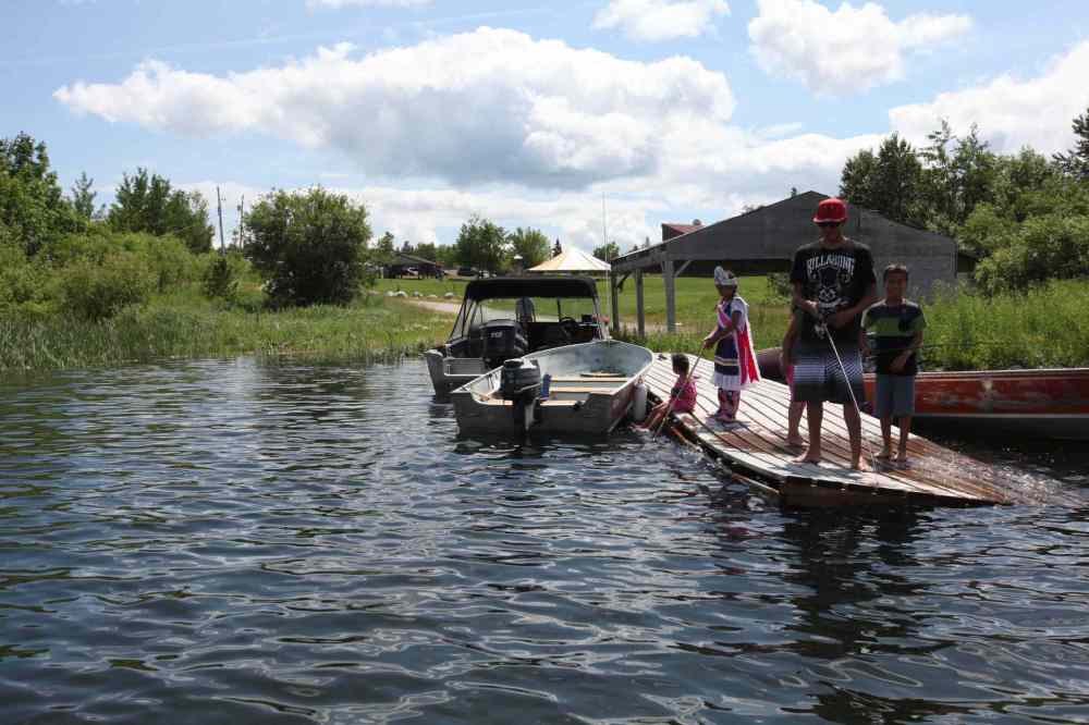 RUTH BONNEVILLE / WINNIPEG FREE PRESS FILES
Shoal Lake No. 40 First Nation residents at the dock to their man-made island in 2014, 100 years after their land was flooded to provide water to Winnipeg.