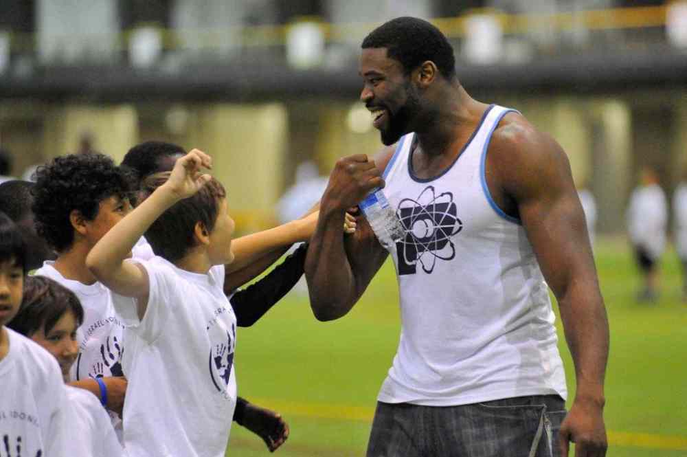 DOUGLAS LITTLE / WINNIPEG FREE PRESS FILES
Israel Idonije greets a group of kids during his annual all-star football camp in Winnipeg. Idonije has decided to retire from football after 11 seasons in the NFL.