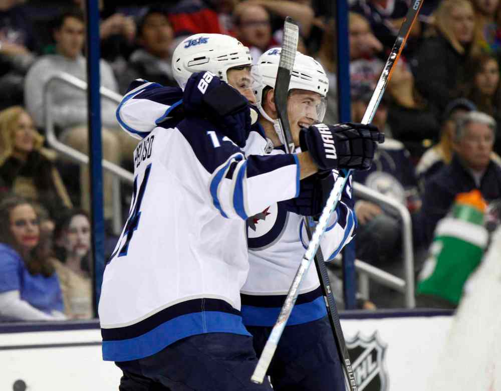 Paul Vernon / The Associated Press
Winnipeg Jets' Andrew Copp, right, celebrates with teammate Anthony Peluso after scoring a goal against the Columbus Blue Jackets during the first period of an NHL hockey game in Columbus, Ohio, Saturday.