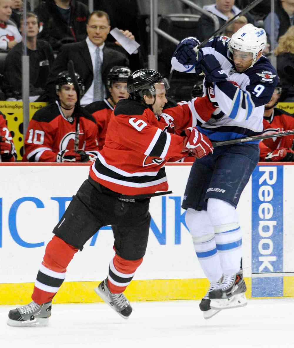 Bill Kostroun / the associated press
New Jersey Devils defenceman Andy Greene checks Winnipeg Jets forward Evander Kane during the first period of an NHL game in Newark, N.J., Monday.